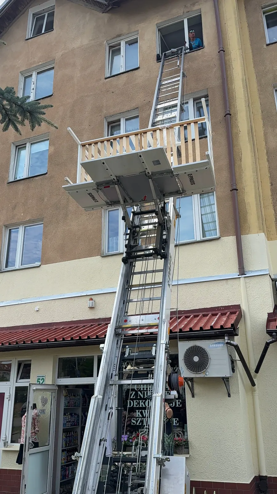Zewnętrzna winda PAUS z platformą ustawioną przy oknie budynku